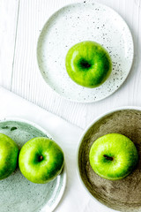 Healthy green food with apples on plates white background top view