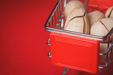 Background: pecan on a red background in a miniature trolley