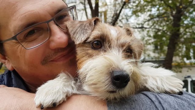 White puppy with adult man outdoors