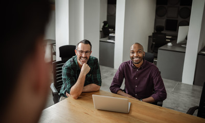 POV Businessmen smiling and interacting in coworking office workspace