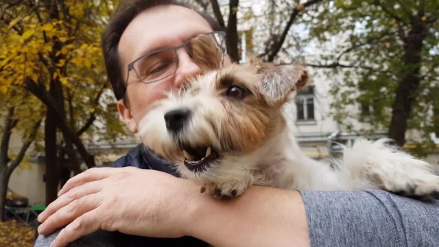 White puppy with adult man outdoors