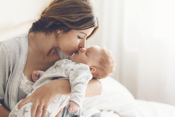Loving mom carying of her newborn baby at home
