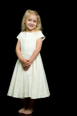 Naklejka premium Portrait of a cute little girl on a black background. Happy chil