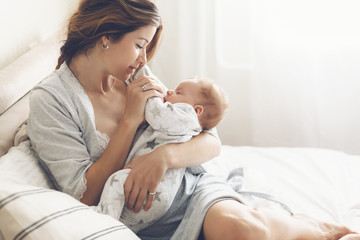 Loving mom carying of her newborn baby at home