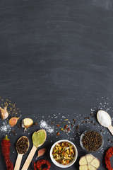 Colourful set herbs and spices and dry vegetable for cooking in wooden spoons and bowls on dark background with copy space. top view. vertical layout