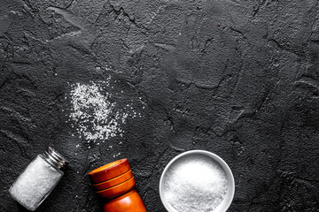 salt in glass bottle scattered on dark table background top view space for text