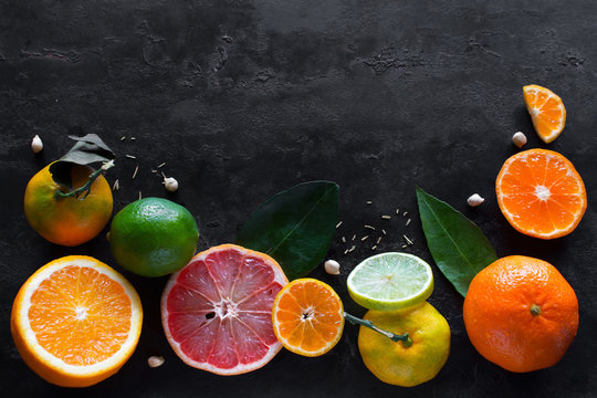Fresh citrus fruits (orange, mandarin, lemon, lime, grapefruit) on a black background with place for text. concept vitamins for immunity © itakdalee