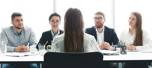 Woman at job interview talking with members of management
