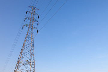 High voltage tower with blue sky background. High voltage pole.