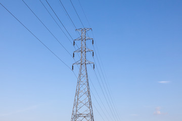 High voltage tower with blue sky background. High voltage pole.