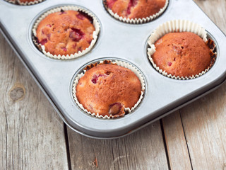 Freshly baked cherry muffins closeup in baking tray