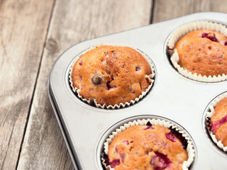 Freshly baked cherry muffins closeup in baking tray