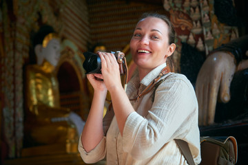 Portrait of a smiling young woman visiting a Buddhist temple in Myanmar.