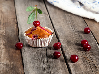 Freshly baked cherry muffins closeup on a rustic table