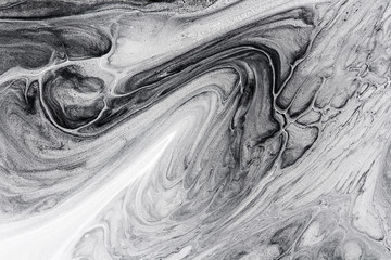 monochrome abstract background formed by mixing white and black paints