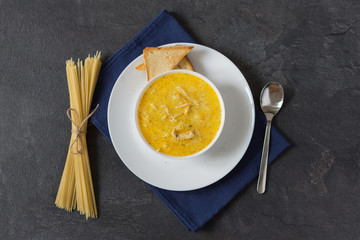 Cream cheese soup with spaghetti and chicken meat at the back background.
