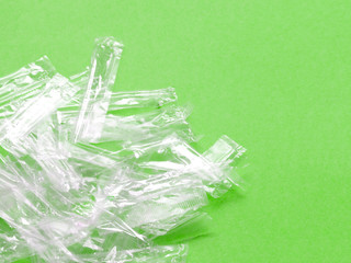 Pile of transparent plastic wrapping rubbish on a green background.
