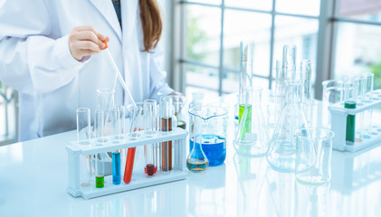 Young girl scientist making experiments chemical in glass tube in the laboratory room