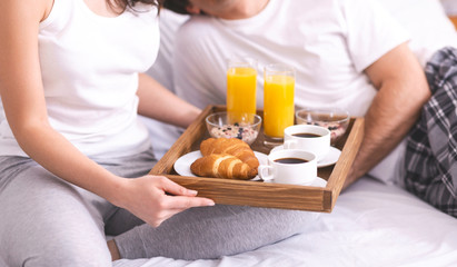 Obraz na płótnie Canvas Loving caucasian couple enjoying breakfast in bed