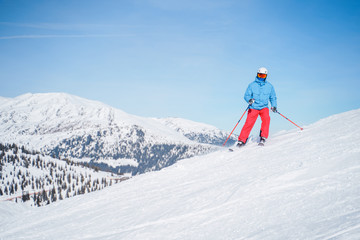 Fototapeta na wymiar Athletic men in helmet skiing on snowy slope.
