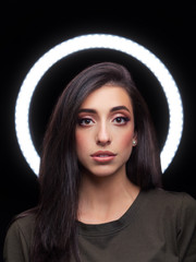 Beautiful young caucasian woman trendy look portrait with ring light halo black background for makeup artist portfolio in film effect colors