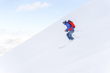 Naklejka na ściany i meble Side photo of athlete man with backpack skiing