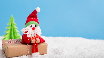 Cute toy Santa Claus preparing holiday presents