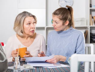 Portrait of mature woman and daughter with documents