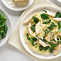 Spaghetti with spinach leaves, grilled chicken breast and cheese