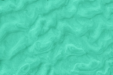A top down shot of trendy mint toned river sand bottom full of texture and salt marks. Useful as abstract surreal background.