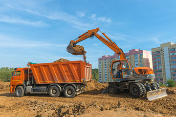 The modern excavator performs excavation work on the construction site.