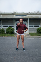 Confident sporty woman doing success thumbs up gesture. Workout goals and fitness motivation concept.