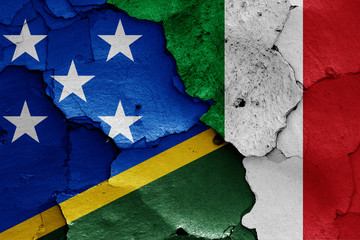 flags of Solomon Islands and Italy painted on cracked wall