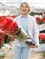 Smiling woman with flowering Poinsettias