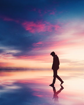 walking on the beach on orange sunset background