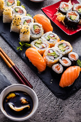  Sushi Set Sashimi und Sushirollen auf Steinschiefer serviert