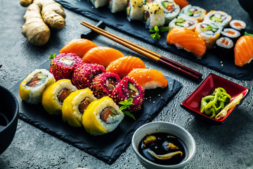  Sushi Set Sashimi und Sushirollen auf Steinschiefer serviert
