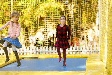 little girls having fun as they jump on trampoline