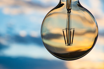 Sunset in a light bulb. Electricity concept. Earth hour. Energy consumption and environmental...