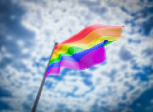 LGBT flag on cloudy sky background