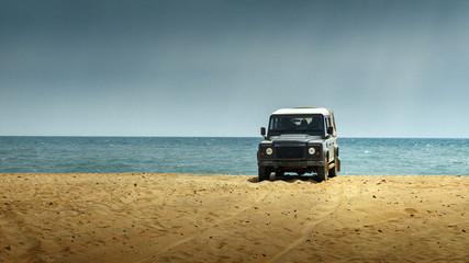 Fototapeta na wymiar SUV car on the beach. Adventure Travel Concept and Lifestyle with copy-space