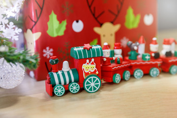 Christmas wooden train toys with snowman and friends and gift box in background.