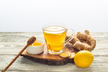 Ginger tea with lemon and honey on a white wooden background. Hot healthy winter drink