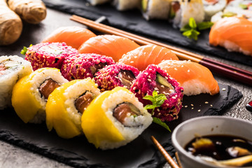 top view of delicious sushi set on slate board and chopsticks