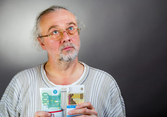 A man holds in his hands a bundle of euros and rubles and doubts what to take.