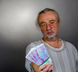 A man offers a pack of notes for 500 euros.