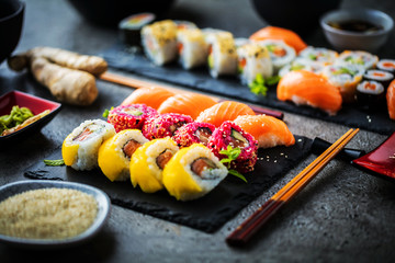  Sushi Set Sashimi und Sushirollen auf Steinschiefer serviert