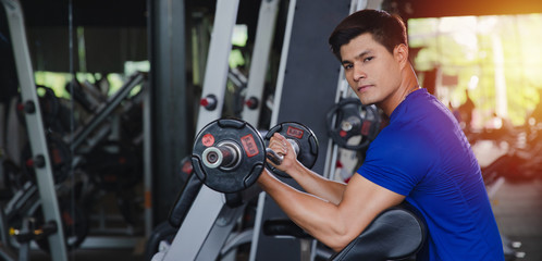 Fototapeta na wymiar Healthy Asian man workout in gym training sport with dumbbell with sportswear