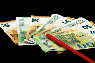 Rotstift auf Euro Geldscheine auf schwarzem Hintergrund