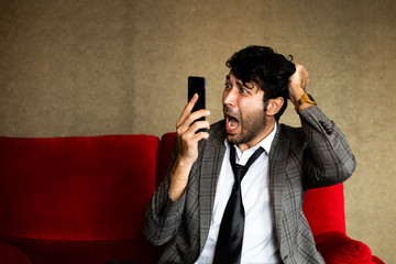 Business man with funny and crazy face action with mobile phone